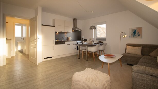 Um apartamento moderno com cozinha, sala de jantar e sala de estar.