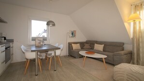 Um espaço compacto com área de refeições, pequeno espaço de cozinha e sofá.