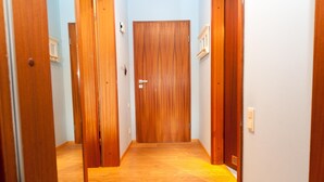 A hallway with wooden doors and a light blue wall. - Vacation apartment for up to 4 people (2 adults + 2 children) (Hörnum auf Sylt)