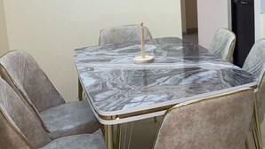 A conference room with a marble table and cushioned chairs.