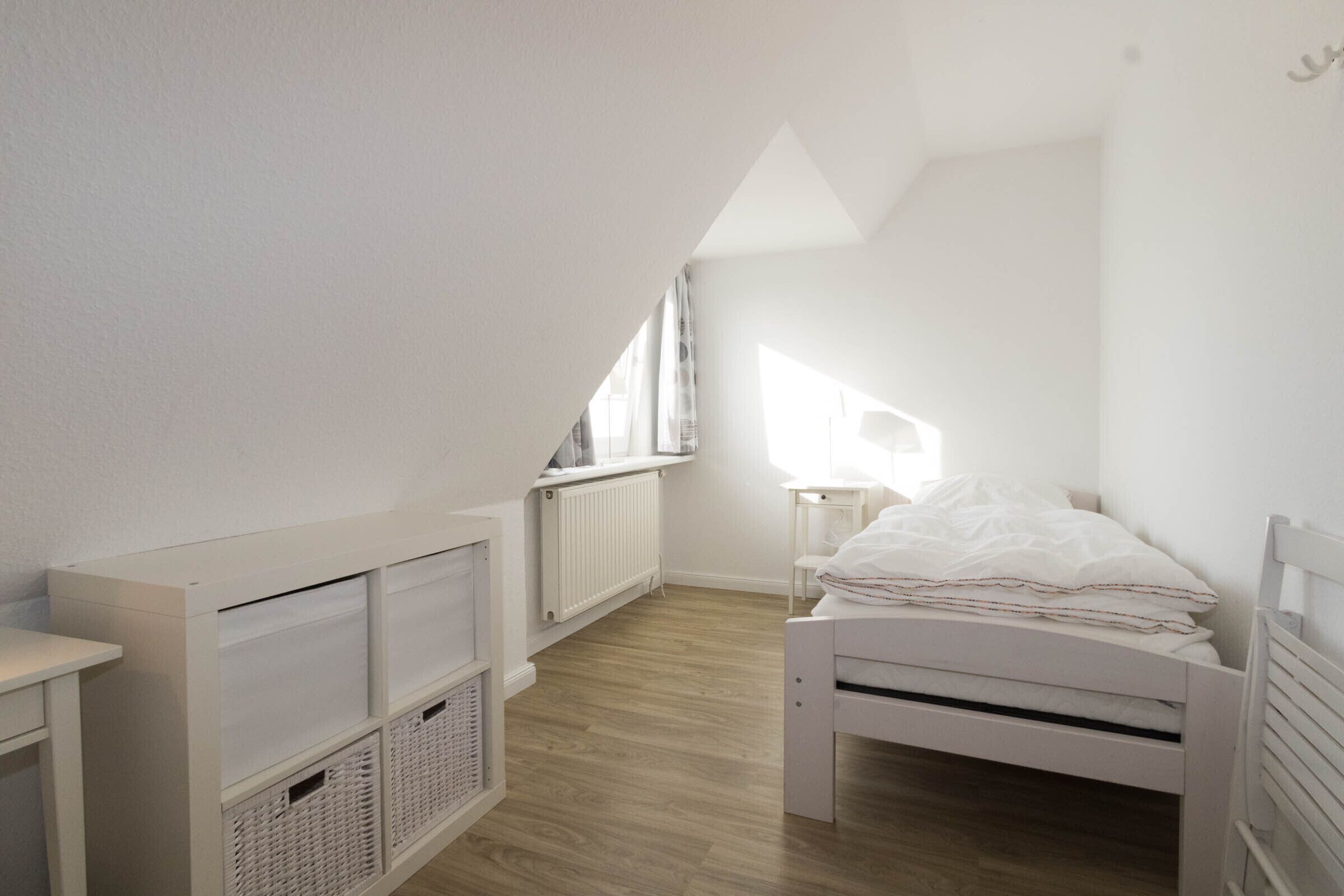 Un dormitorio infantil con una cama litera, un escritorio y un radiador.