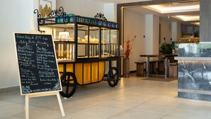 Un carrito de comida con un panel de menú en el vestíbulo de un hotel.