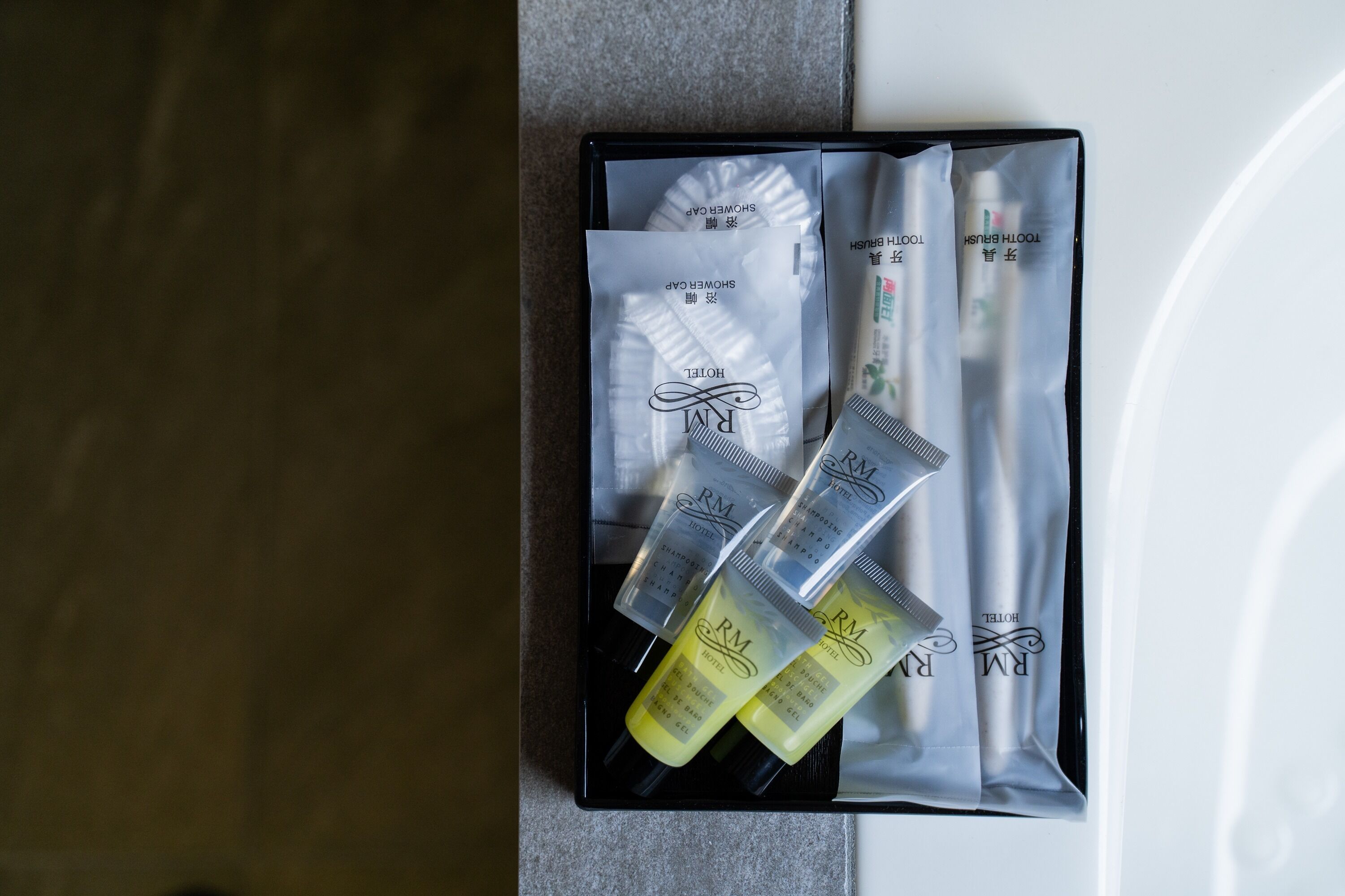 A hotel gift set with toiletries including a shower gel, a toothbrush, and a comb.