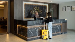 Un mostrador de recepción con encimera de mármol y un letrero con las letras 'RM' en dorado.