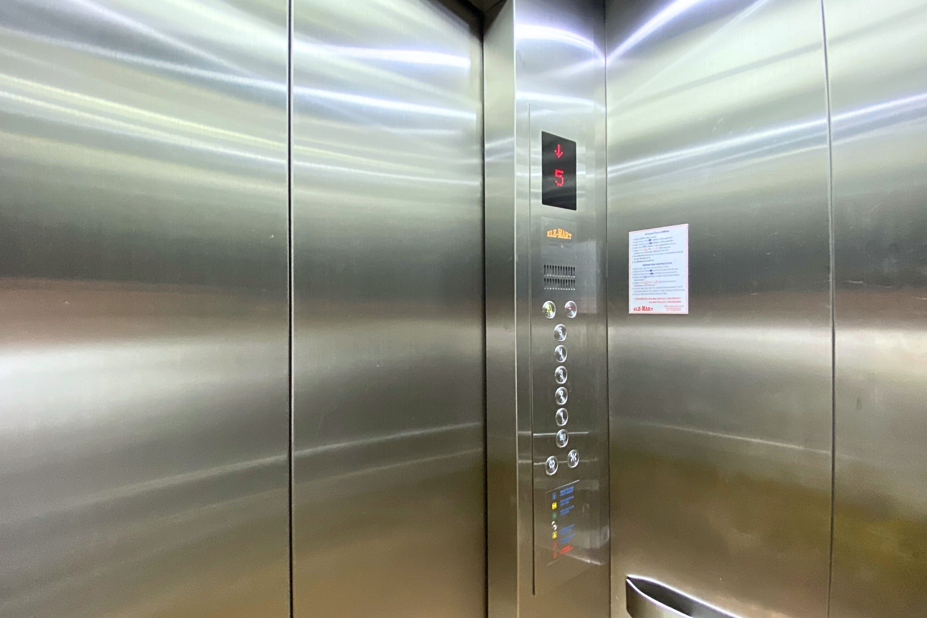 An elevator interior with a digital display indicating the floor number and a set of buttons for floor selection.