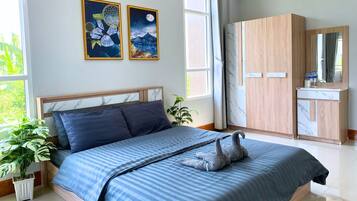 A modern bedroom with a bed, a nightstand, a potted plant, and a wardrobe.