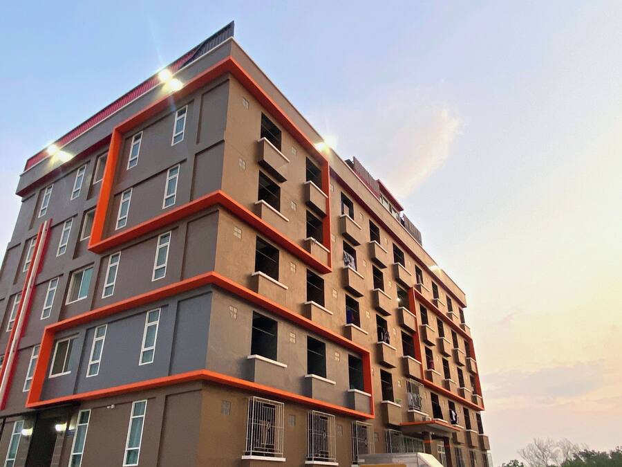 A multi-story building with a modern architectural design, featuring balconies and large windows.