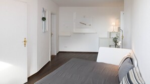 Et hotelværelse med en seng, et natbord, et spejl og et billede hængende på væggen.