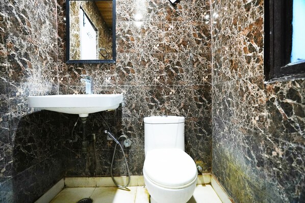 A bathroom with a sink, toilet, and mirror.