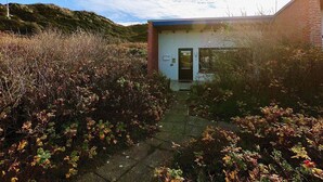 Un piccolo edificio con facciata in mattoni, una porta e una finestra.