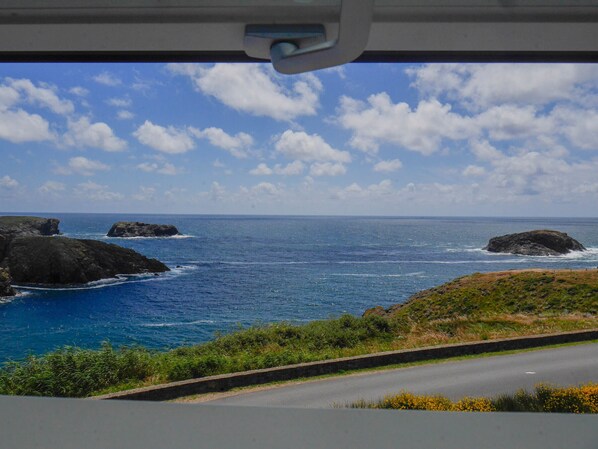 A coastal road with rocky outcrops and the ocean.