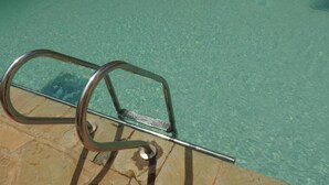 A clear swimming pool with a metal ladder leading into it. - Omega Gardens Hotel (Nanyuki)