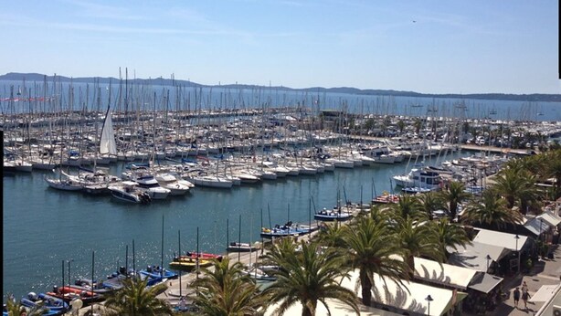 A marina with numerous boats docked, surrounded by palm trees and a clear sky. - Hyères Port T2 with Air Conditioning and Wifi, Sea View (Hyères)