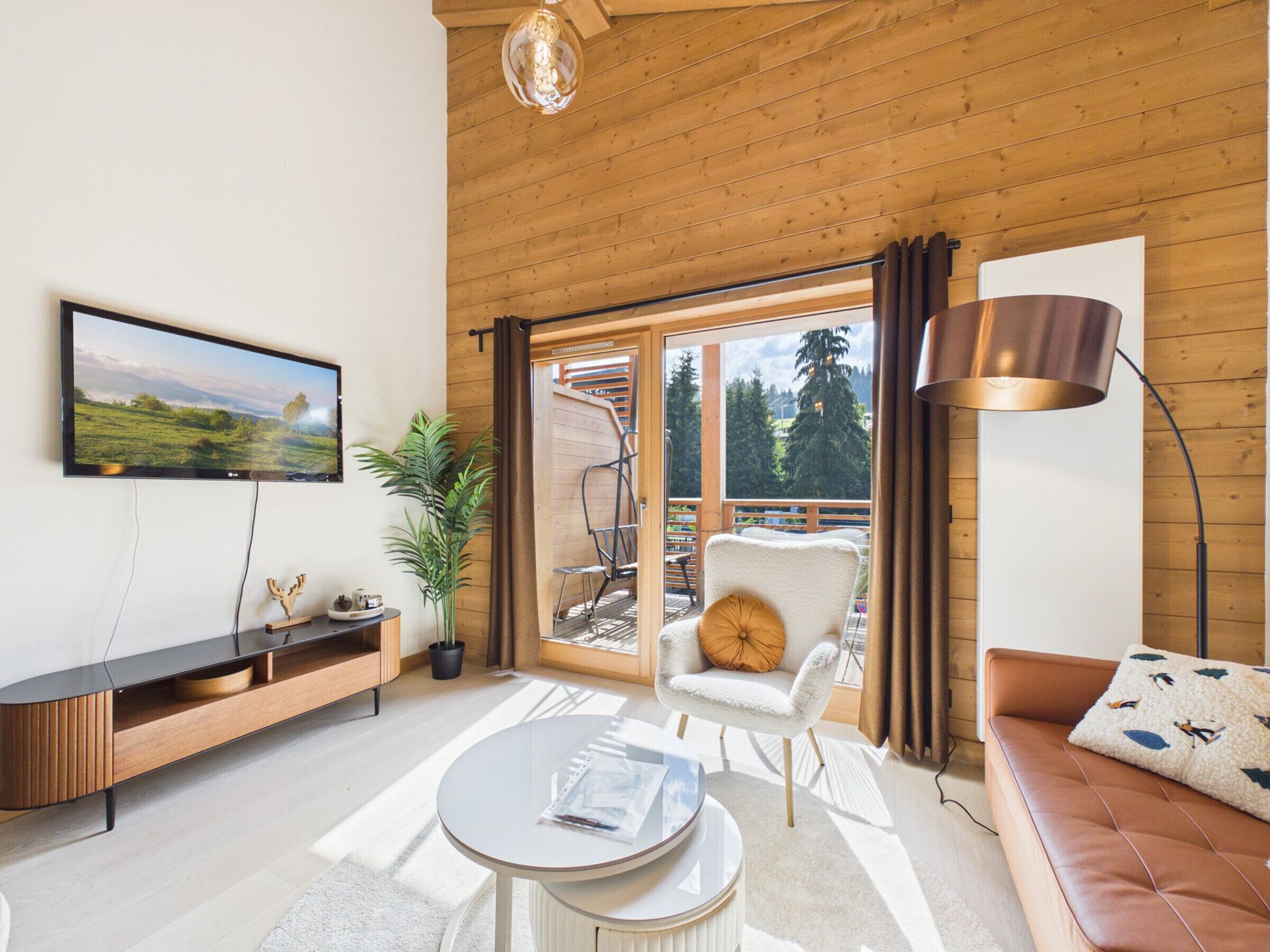 A modern living room with a TV, a sofa, a coffee table, and a chair.