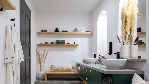 A modern bathroom with a large mirror, a sink, and a vanity. There are shelves above the mirror and a towel rack on the left. - Sleeps 9 Outdoor Space PingPong Table (Oaxaca)