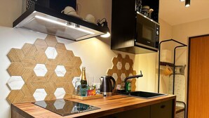 A modern kitchen with a wooden countertop, a built-in microwave, and a hexagonal tile backsplash. - Beautiful 1-bed Apartment in Klaipeda (Klaipeda)