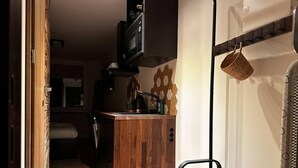 A compact kitchen with a wooden countertop, a microwave, and a hanging basket. - Beautiful 1-bed Apartment in Klaipeda (Klaipeda)