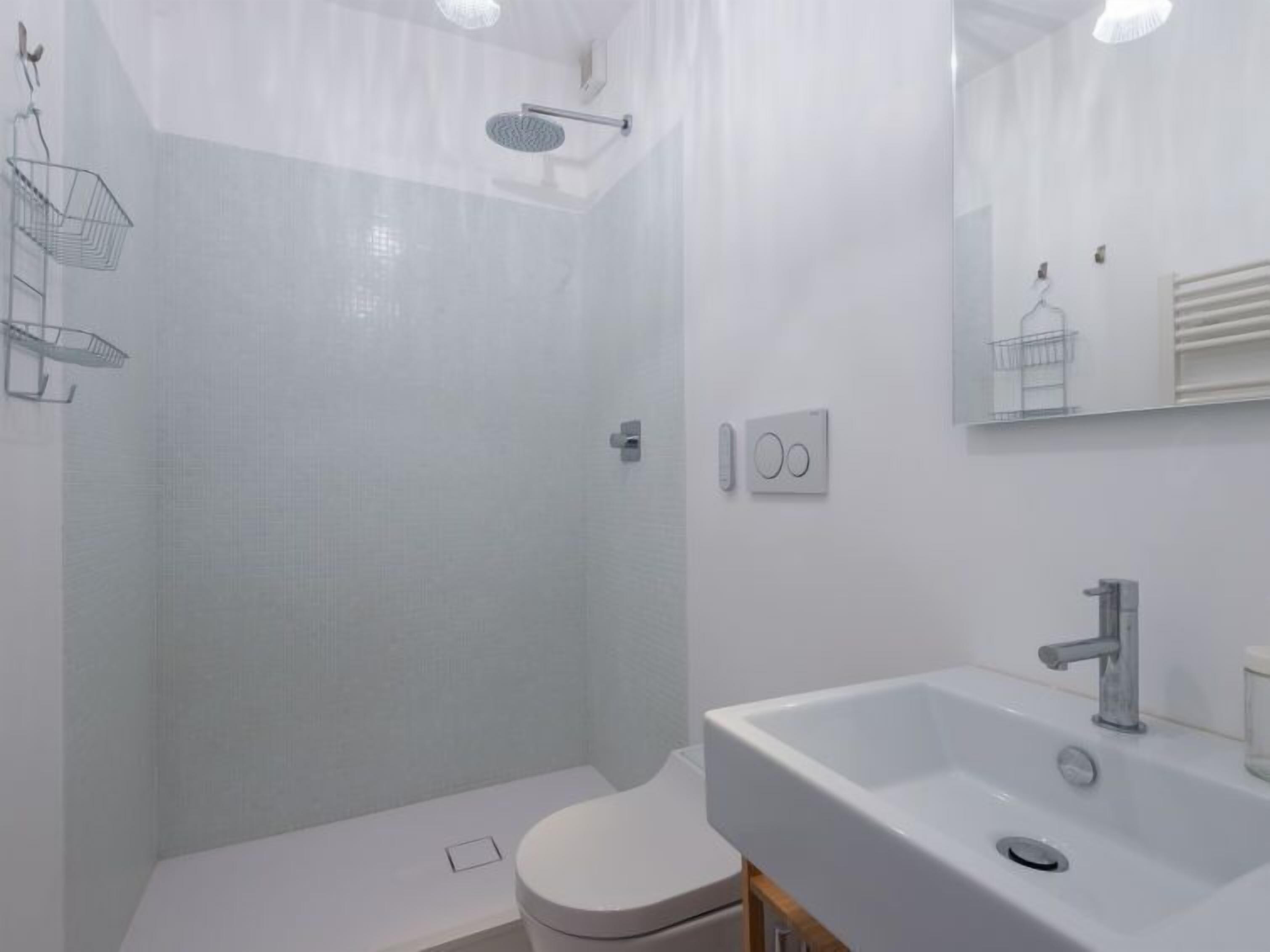 Une salle de bain moderne équipée d’une douche, de toilettes et d’un lavabo.