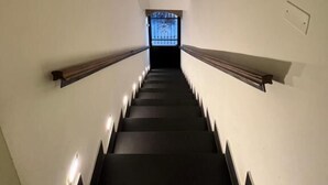 A narrow staircase with a stone ceiling and a view of a building through a window at the top. - Residenza Toledo (Naples)