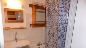 A bathroom with a sink, mirror, and shower. - Cozy studio in village center, pets allowed, private parking (Samoëns)