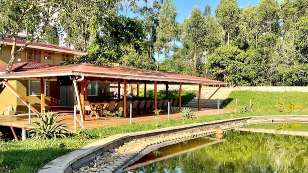 A covered outdoor seating area with a pool and a stone pathway. - Zebi Ecolodge (Hoima)