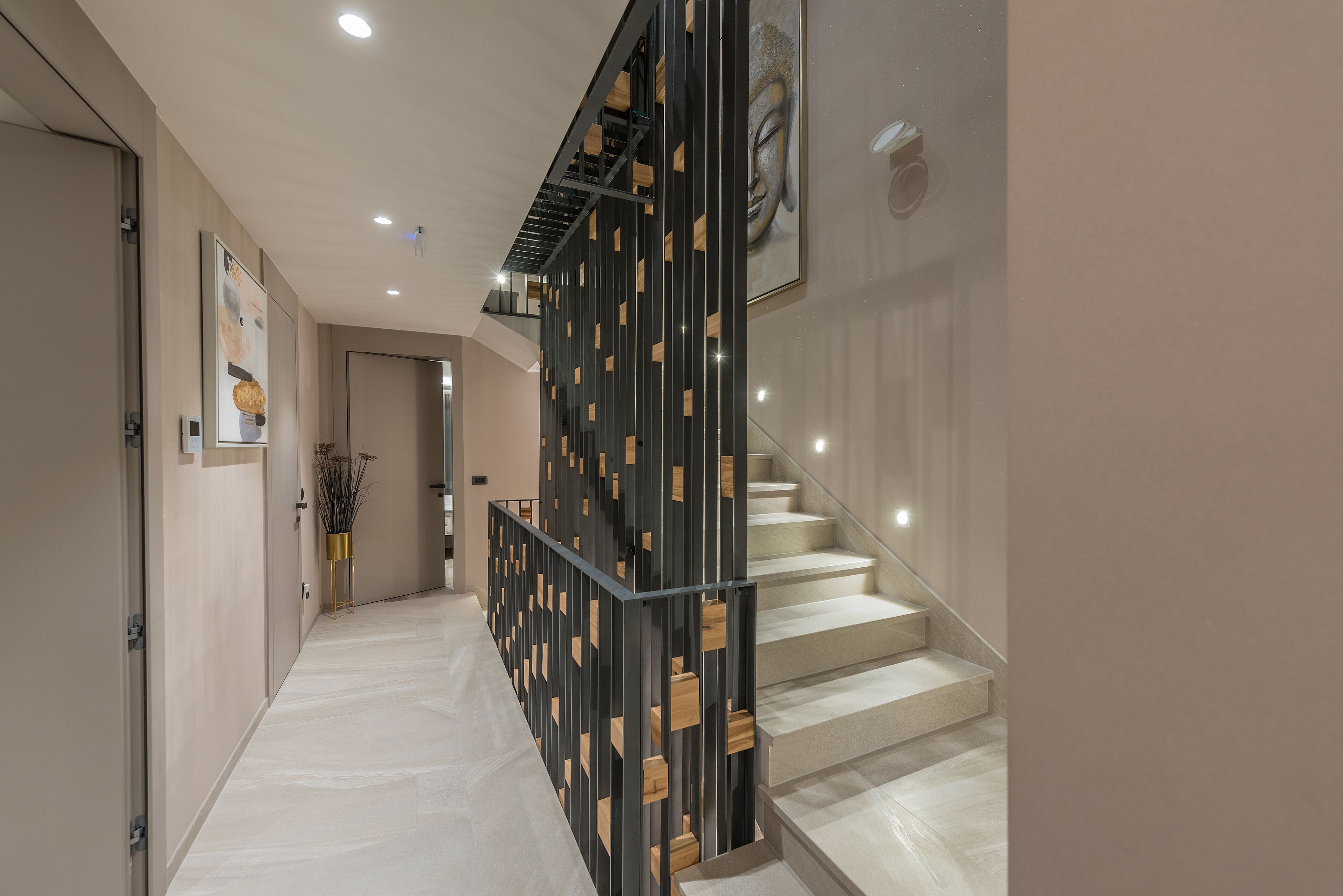 Un intérieur moderne agrémenté d’un escalier, d’un panneau décoratif mural et d’une œuvre d’art encadrée accrochée au mur.