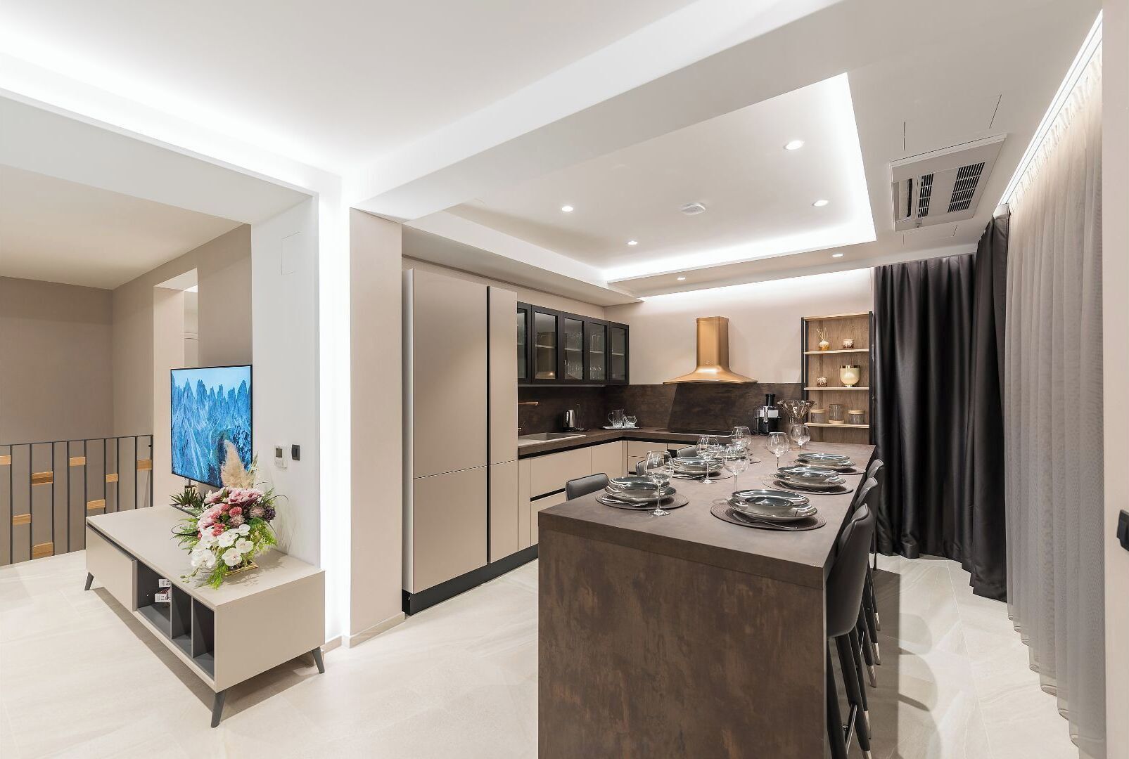Een moderne keuken met een centraal eiland, inbouwvoorraden en een eethoek klaar voor een maaltijd.