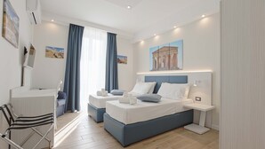 A modern hotel room with a large bed, a desk, and a chair. - Esseneto Rooms (Agrigento)