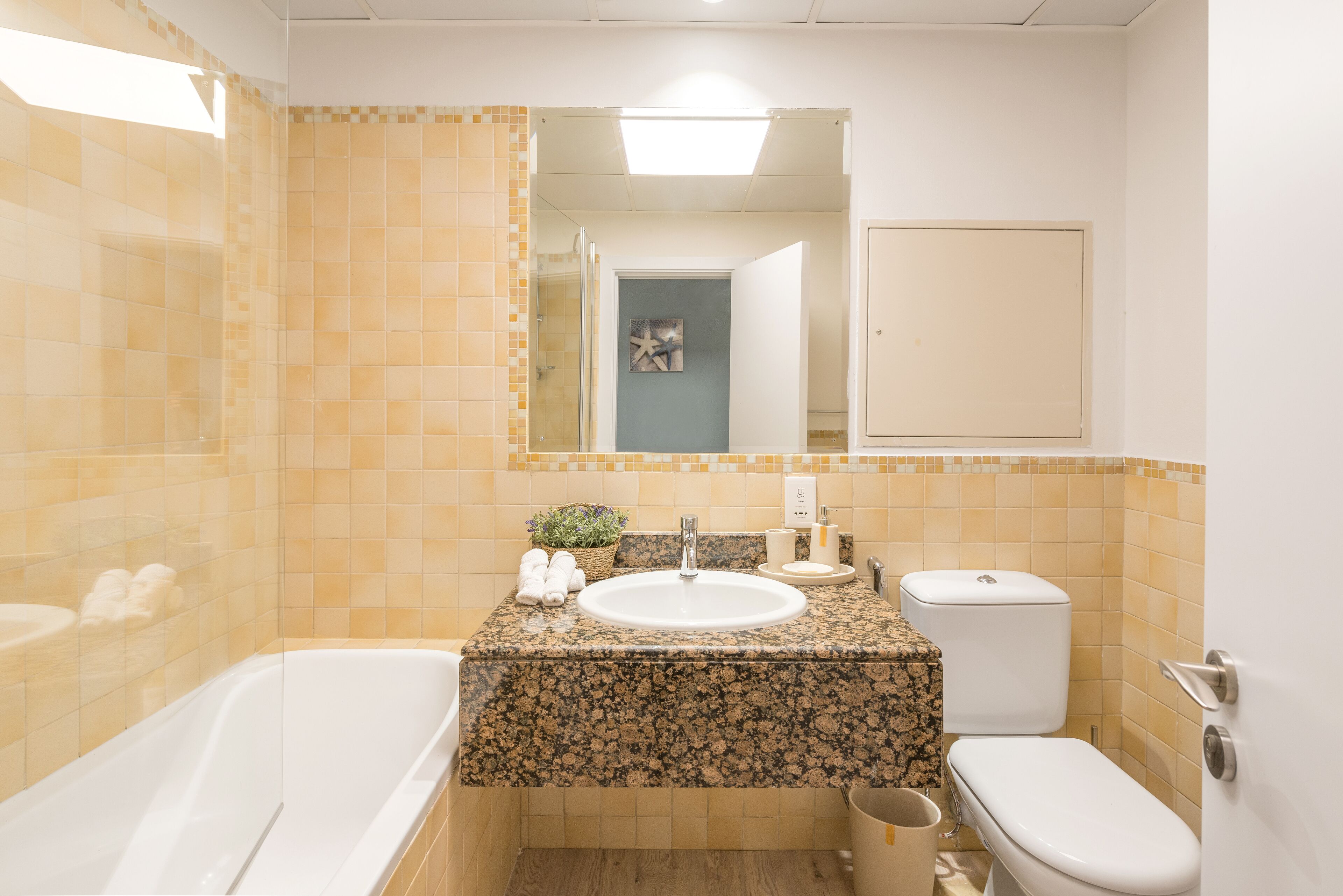 Baño con bañera, lavamanos, inodoro y zona de ducha.