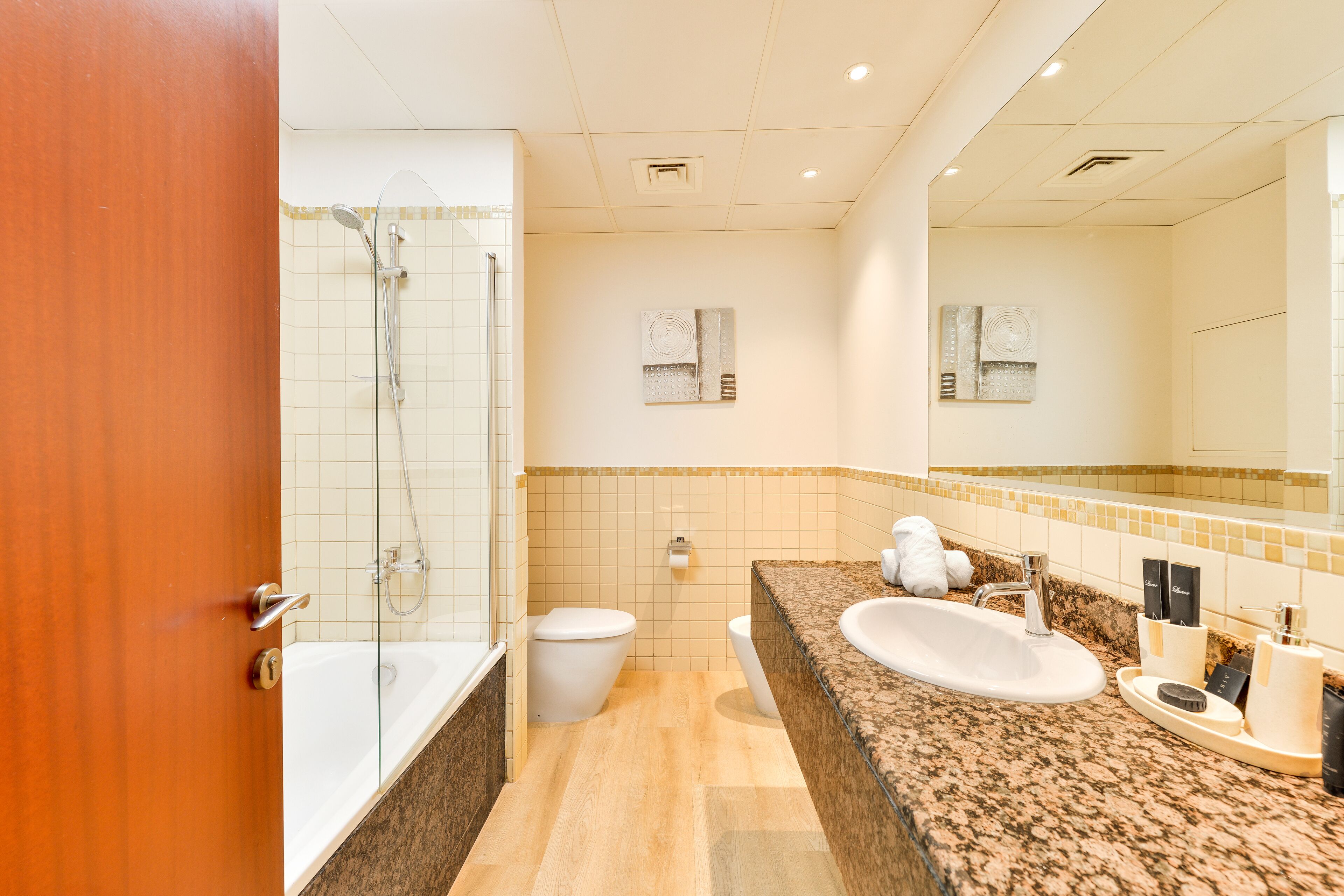A modern bathroom with a bathtub, toilet, and sink.
