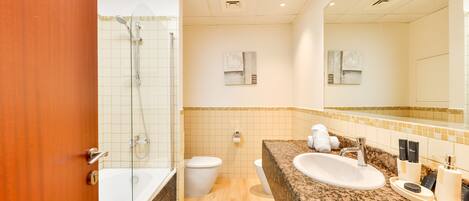 A modern bathroom with a bathtub, toilet, and sink.
