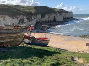 Two boats on a sandy beach with cliffs in the background. - Rowan Boutique Lodge for Couples With a dog (York)