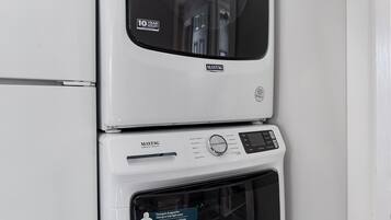 A stacked washer and dryer unit with a 10-year warranty label.