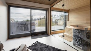 A modern interior with a large sliding glass door leading to a balcony, a stone fireplace, and a minimalist design. - Stunning view in holiday home (Gol)