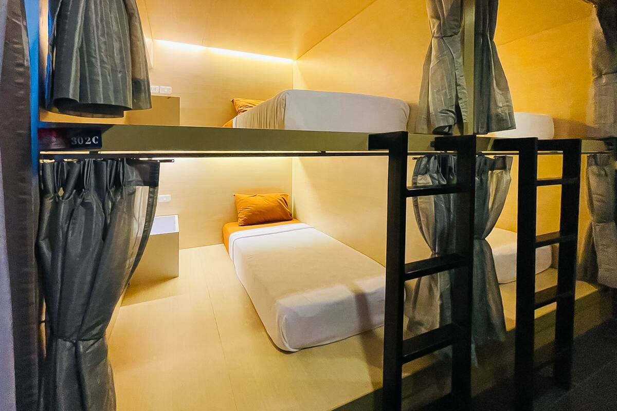 A bunk bed room with a small table and a chair.