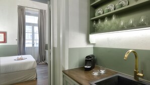 A compact kitchenette with a sink, a coffee machine, and a shelf with glassware. - Athinaidos Boutique Loft by K&K (Αθήνα)