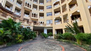 Un hotel a più piani con un cortile centrale, balconi e vegetazione rigogliosa.