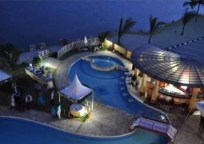 A swimming pool area with a covered seating area and a small pavilion. - Shanzu Beachfront Suites (Mombasa)