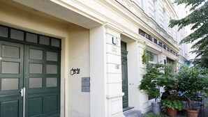 Ein Gebäude mit einer grünen Doppeltür, einem Schild mit der Zimmernummer 7 und einer kleinen Außenfläche mit Topfpflanzen.