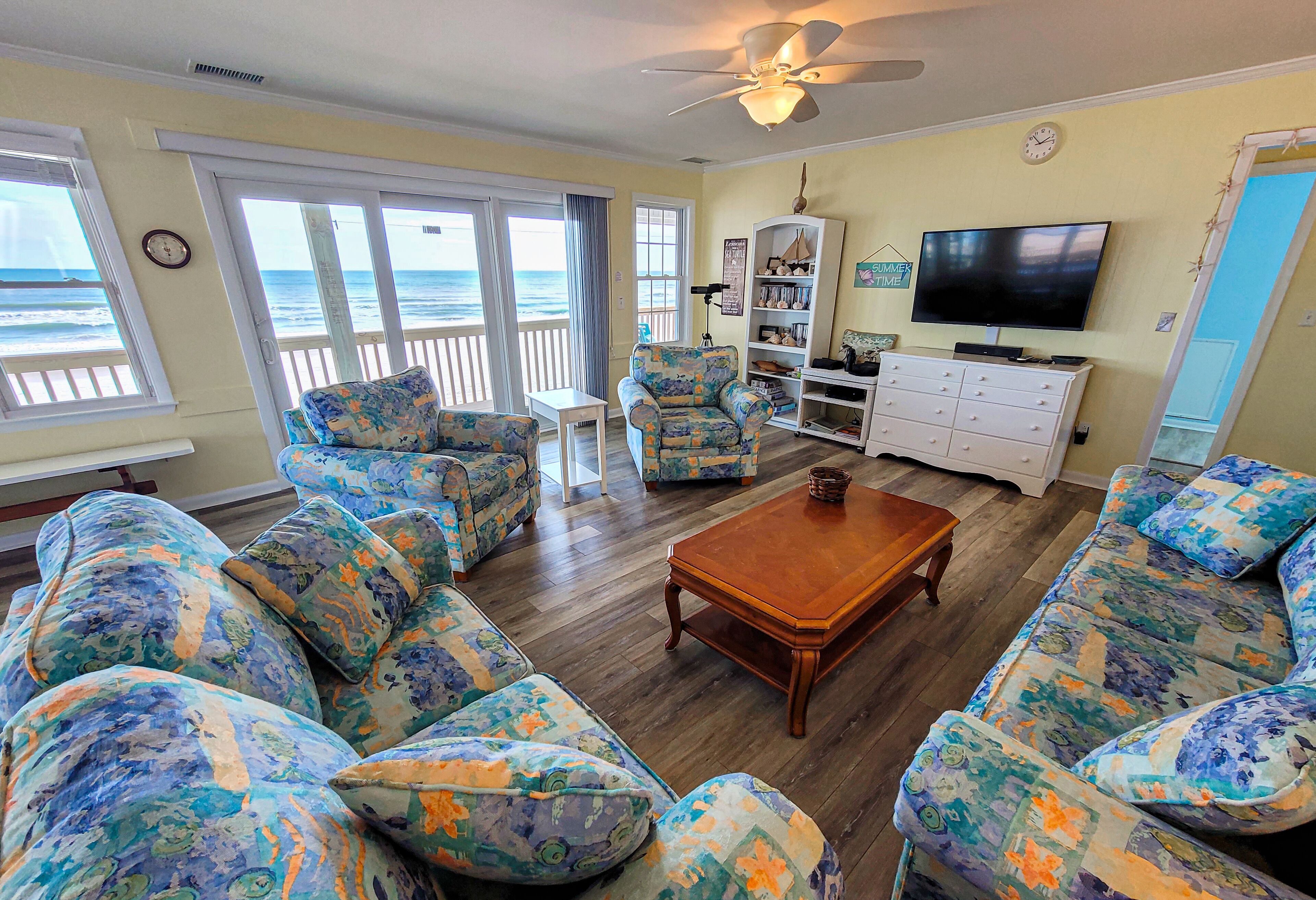 A living room with a sofa set, a coffee table, a TV, and a bookshelf.