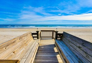 Una passerella di legno che conduce a una spiaggia con vista libera sull'oceano.