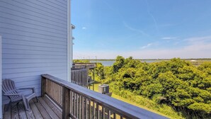 A wooden deck with a view of a lake and trees.