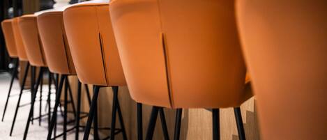 A row of orange chairs with black metal legs, arranged in a row.