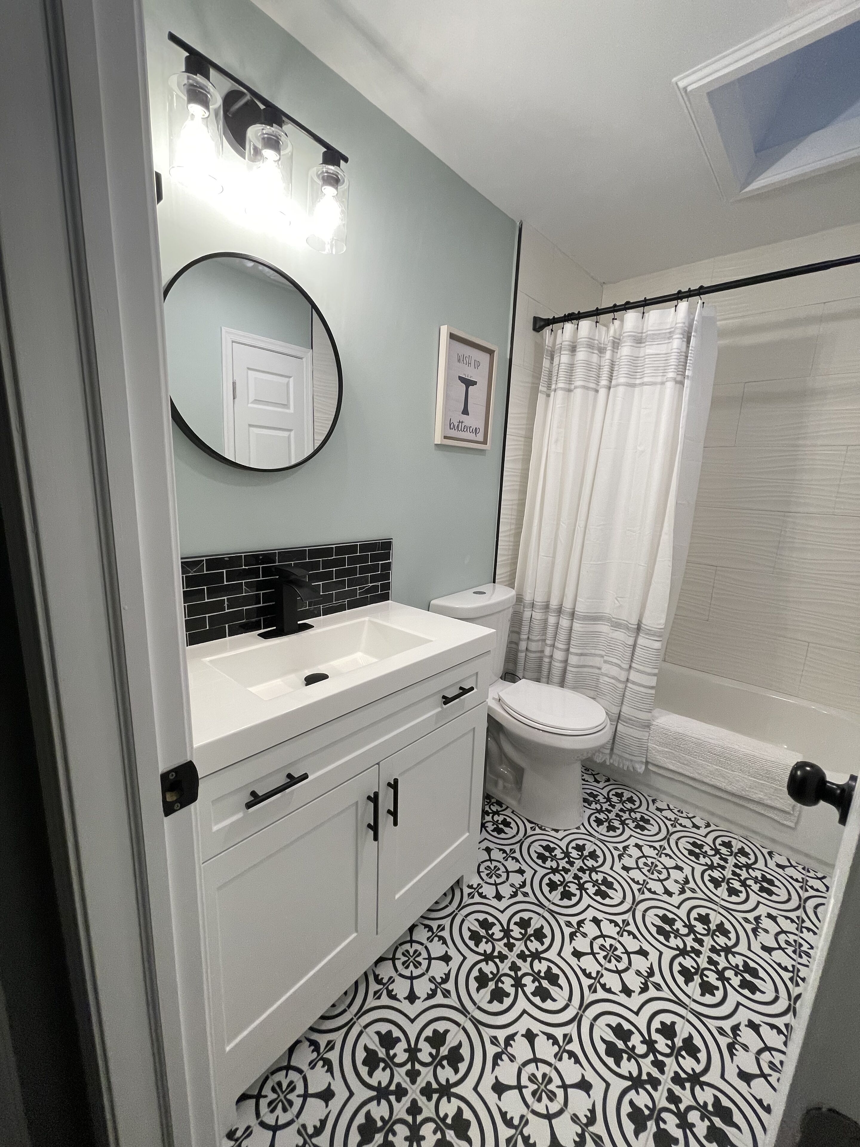 A bathroom with a white sink, toilet, and a shower curtain.