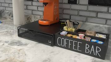 Een keuken met een koffiebar, een papieren handdoekdispenser en een koffiezetapparaat.