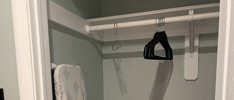A bathroom with a shower curtain, a towel rack, and an iron.