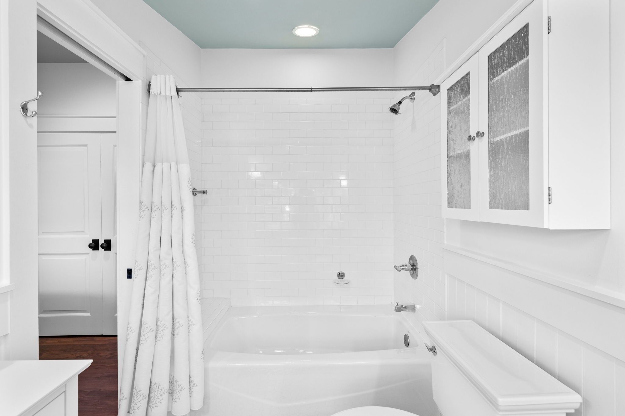 A modern bathroom with a bathtub, toilet, and shower area.