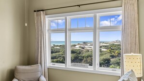 Una habitación con un ventanal que ofrece vistas a un paisaje costero.