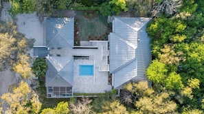An aerial view of a modern house with a swimming pool, surrounded by dense trees. - Upscale Beach Estate With Private Pool + Carriage House And Less Than 300 Yards From The Beach 6 Bedroom Home by RedAwning (Santa Rosa Beach)