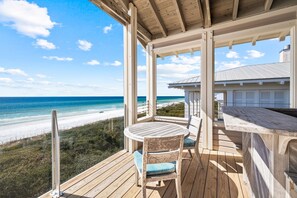Enjoy a tranquil ocean view from this deck with a round table and two chairs.